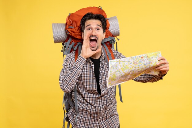 Vooraanzicht jonge man die gaat wandelen met een rugzak met kaart op gele achtergrond trip air nature company campus forest