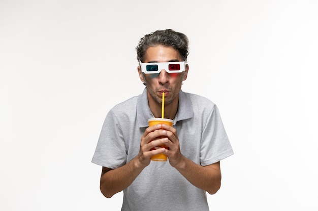 Vooraanzicht jonge man frisdrank drinken en het dragen van een zonnebril op wit bureau