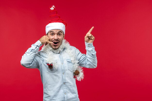 Vooraanzicht jonge man imiteert telefoongesprek op rode bureau vakantie kerstmis