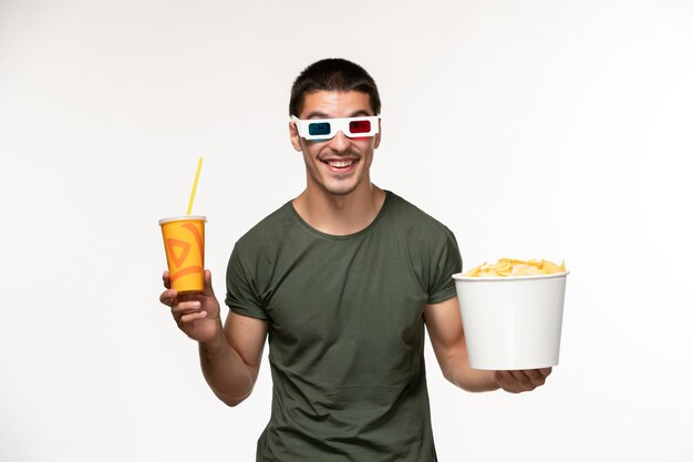 Vooraanzicht jonge man in groen t-shirt met aardappel cips frisdrank in d zonnebril op witte muur film mannelijke eenzame film bioscoop