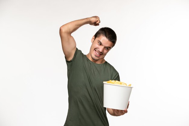 Vooraanzicht jonge man in groen t-shirt met cips op witte muur eenzame film film bioscoop persoon