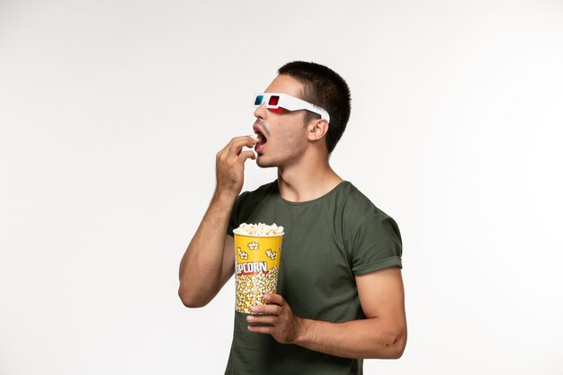Vooraanzicht jonge man in groen t-shirt met popcornpakket in d zonnebril op witte muur film eenzame bioscoop mannelijke films