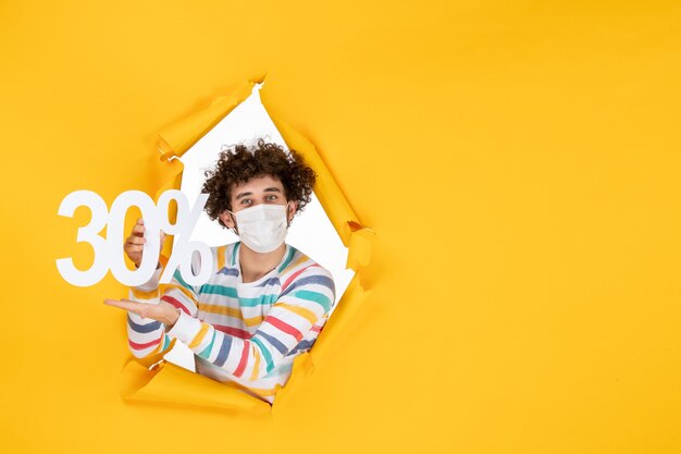 Vooraanzicht jonge man in masker met gele kleur winkelen gezondheid covid- foto pandemische virusverkoop