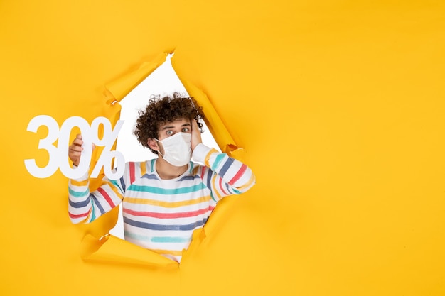 Vooraanzicht jonge man in masker met gele kleur winkelen gezondheid covid- foto's pandemisch virus