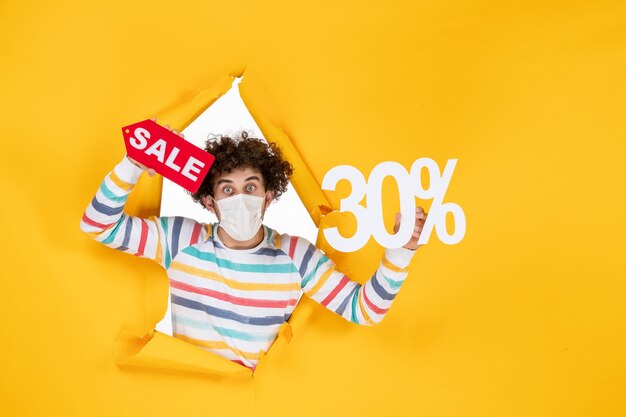 Vooraanzicht jonge man in masker met gele pandemische kleur winkelen rood gezondheid covid virus verkoop