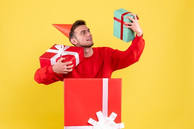 Vooraanzicht jonge man in rood shirt bedrijf presenteert