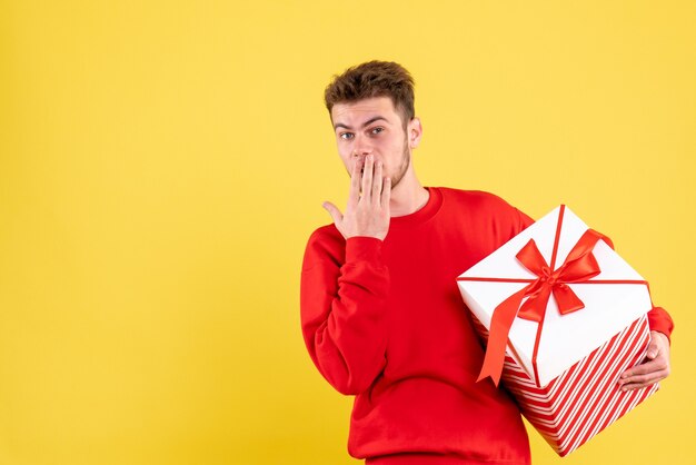 Gratis foto vooraanzicht jonge man in rood shirt met kerstcadeau