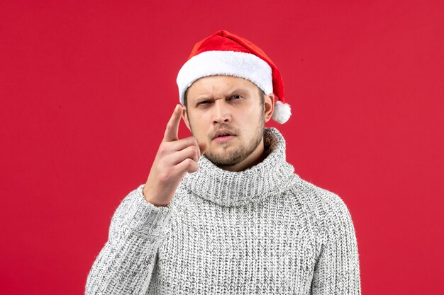 Gratis foto vooraanzicht jonge man in warme trui op rode muur