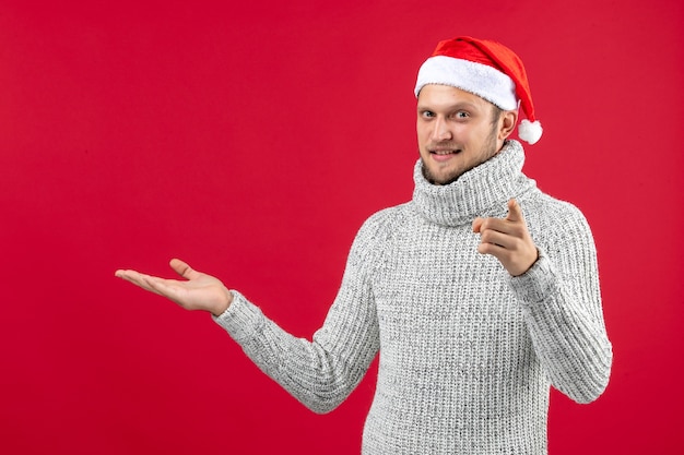 Vooraanzicht jonge man in warme trui op rode tafel nieuwjaar kerst sneeuwvakantie kleur emotie