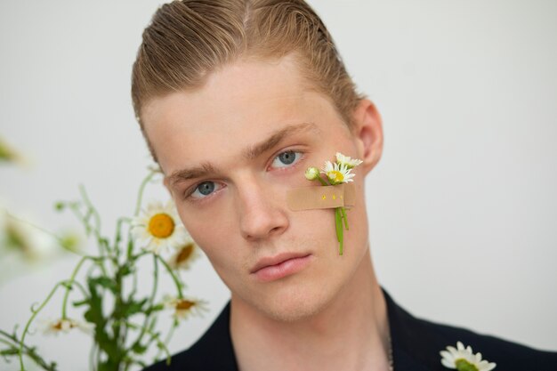 Vooraanzicht jonge man met bloem op de wang