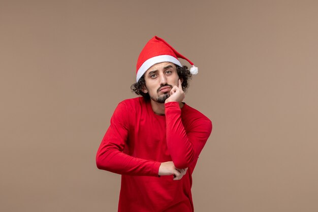 Vooraanzicht jonge man met denken gezicht op bruin bureau emotie kerstvakantie