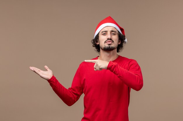 Vooraanzicht jonge man met ernstige uitdrukking op bruine achtergrond emotie vakantie kerst