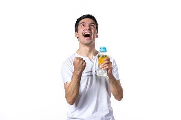 Vooraanzicht jonge man met fles limonade op witte ondergrond