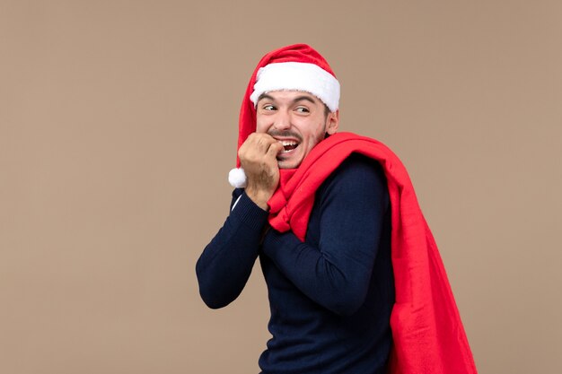 Vooraanzicht jonge man met huidige tas en pet op bruin bureau vakantie kerst kerstman