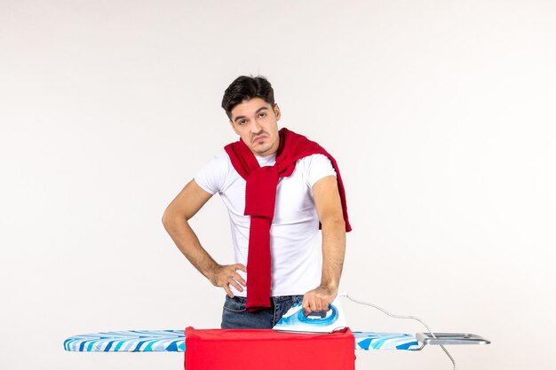 Vooraanzicht jonge man met ijzer op witte achtergrond werk man huishoudelijk werk Wasserij kleur emotie thuis