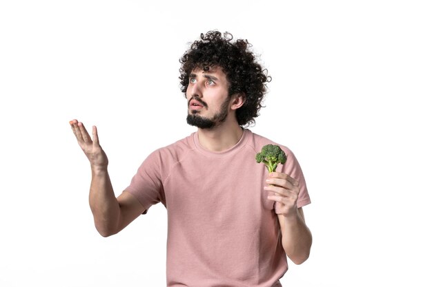 Vooraanzicht jonge man met kleine groene broccoli op witte achtergrond lichaam gezondheid dieet horizontaal menselijk gewicht groentesalade