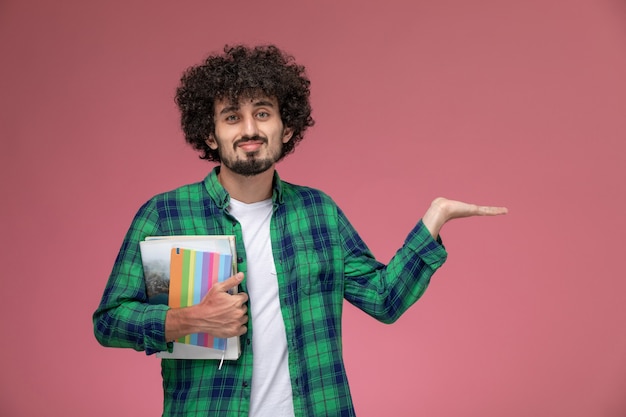 Vooraanzicht jonge man met lege hand met notebooks