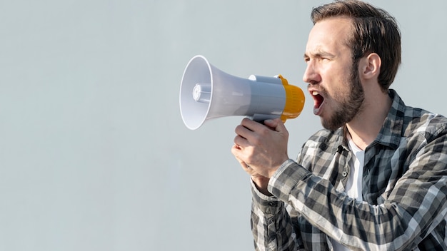 Gratis foto vooraanzicht jonge man met megafoon