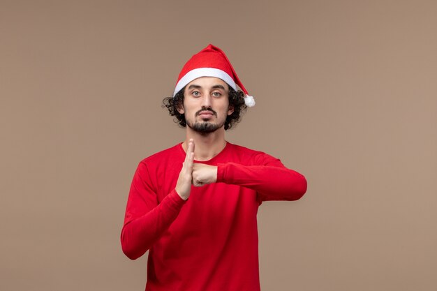 Vooraanzicht jonge man met opgetogen gezicht op bruine achtergrond emotie kerstvakantie
