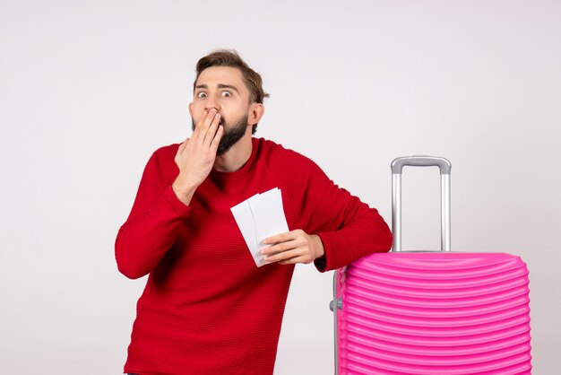 Vooraanzicht jonge man met roze tas en kaartjes houden op witte muur reis vlucht kleur reis toeristische foto