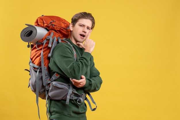 Vooraanzicht jonge man met rugzak die zich voorbereidt op wandelen