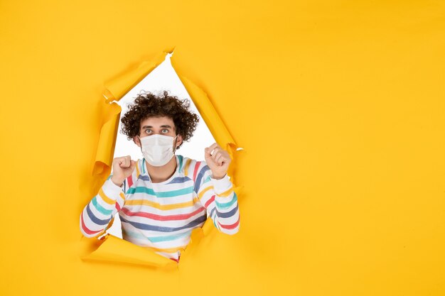 Vooraanzicht jonge man met steriel masker op gele gezondheidskleur covid coronavirus menselijke foto pandemie