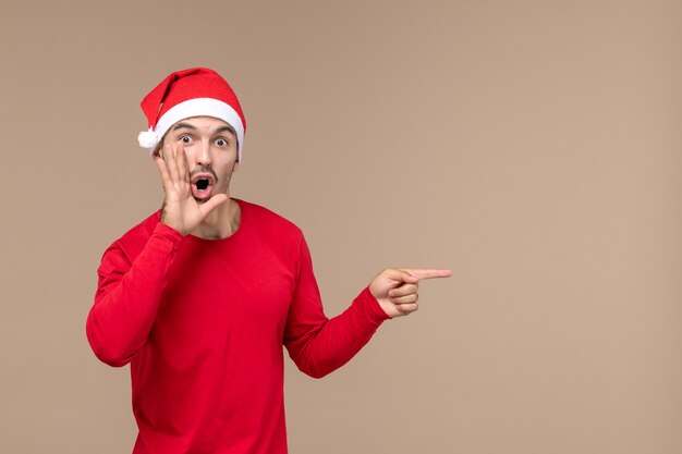 Vooraanzicht jonge man roepen op bruine achtergrond emotie kerstvakantie