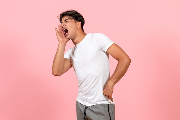 Gratis foto vooraanzicht jonge man schreeuwen in wit t-shirt op roze achtergrond