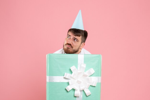 Vooraanzicht jonge man staande in huidige doos benadrukt op roze kleur pyjama party foto emotie slaap xmas