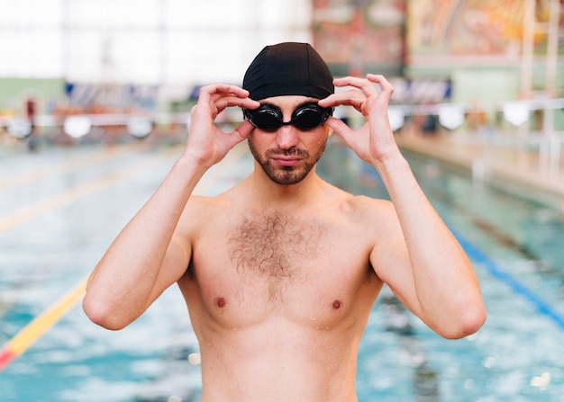 Gratis foto vooraanzicht jonge man zetten zwembril