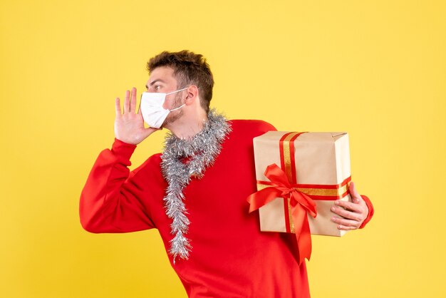 Vooraanzicht jonge mannelijke kerst aanwezig in steriel masker bellen