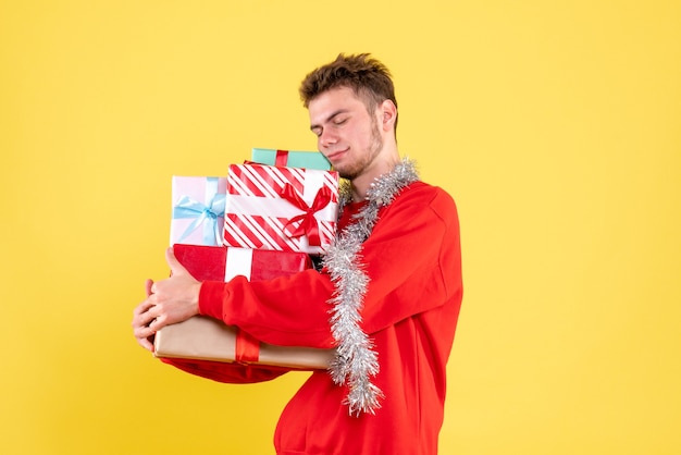 Vooraanzicht jonge mannelijke kerstcadeautjes houden