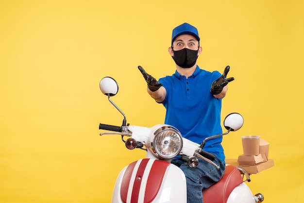 Vooraanzicht jonge mannelijke koerier in blauw uniform op gele achtergrond