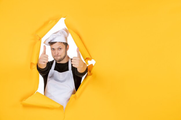 Vooraanzicht jonge mannelijke kok in witte cape en pet verrukt op gele achtergrond voedsel baan blanke man keuken foto kleur keuken