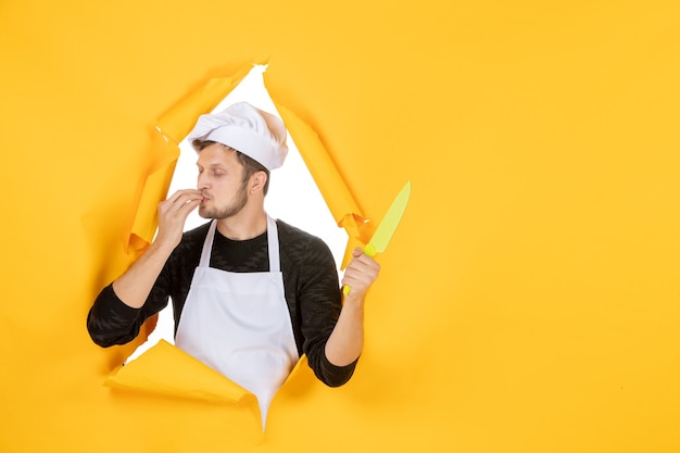 Vooraanzicht jonge mannelijke kok in witte cape op de gele achtergrond witte kleur keuken baan man voedsel foto keuken