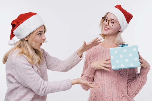 Vooraanzicht jonge meisjes die een geschenk houden