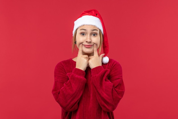 Vooraanzicht jonge vrouw die een lachend gezicht maakt, rode vakantiekerstmis