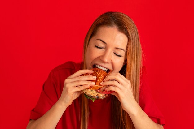 Vooraanzicht jonge vrouw die hamburger eet