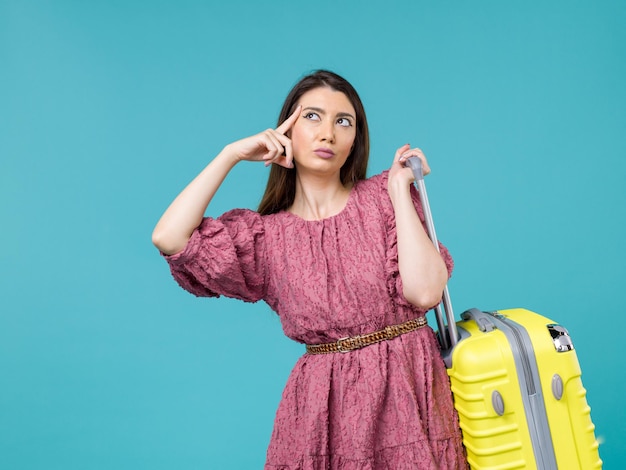 Vooraanzicht jonge vrouw gaat op vakantie met haar gele tas op blauwe achtergrond reis zomer vrouw menselijke reis zee