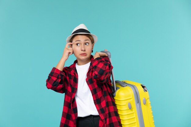 Vooraanzicht jonge vrouw gaat op vakantie met haar gele tas op de blauwe ruimte