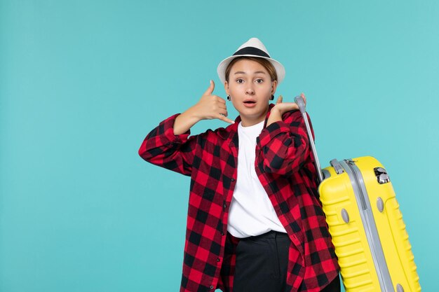 Vooraanzicht jonge vrouw gaat op vakantie met haar gele tas op de blauwe ruimte