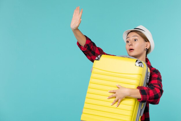 Vooraanzicht jonge vrouw gaat op vakantie met haar grote tas afscheid op blauwe ruimte