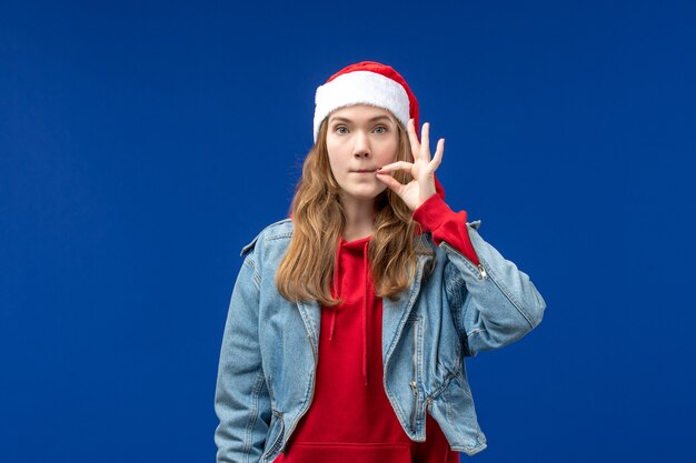 Vooraanzicht jonge vrouw haar mond sluiten op blauwe achtergrond kerst emotie kleur