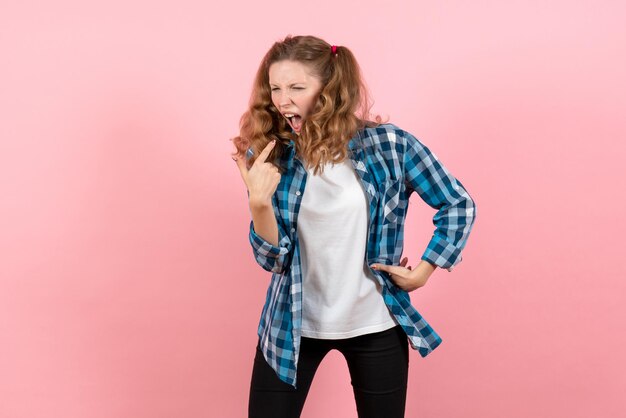 Vooraanzicht jonge vrouw in blauw geruit overhemd met ademproblemen op roze muur jeugd emotie meisjes kid model mode