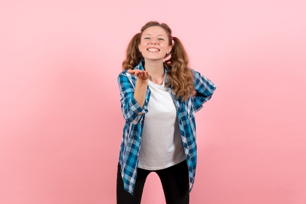Vooraanzicht jonge vrouw in blauw geruit overhemd met gelukkige uitdrukking op roze achtergrond jeugd emotie meisje jongen model mode