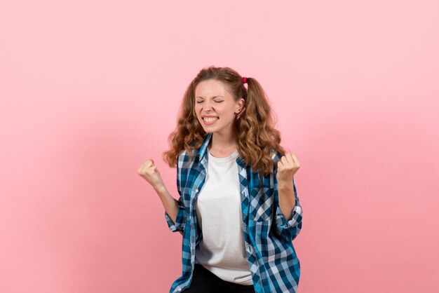 Vooraanzicht jonge vrouw in blauw geruit overhemd op roze muur jeugd emoties meisje mode jongen model