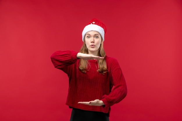 Vooraanzicht jonge vrouw in rode dop met grootte, rode kerstmis voor de feestdagen