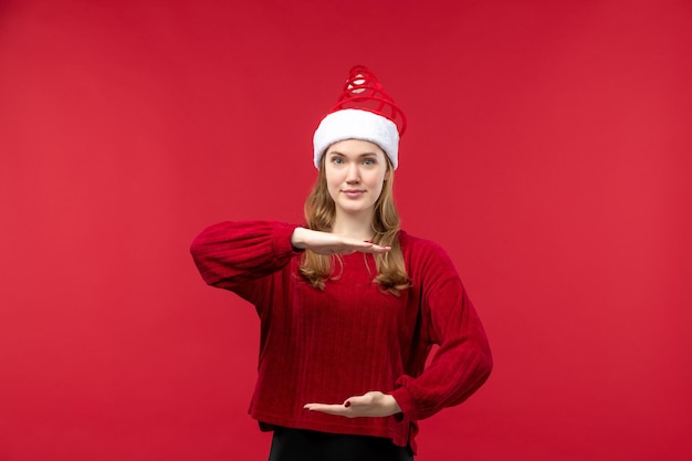 Vooraanzicht jonge vrouw in rode dop met grootte, rode kerstmis voor de feestdagen Gratis Foto
