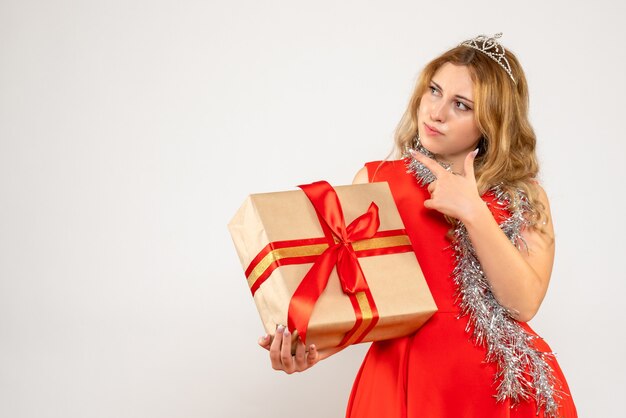 Vooraanzicht jonge vrouw in rode jurk kerstcadeau te houden