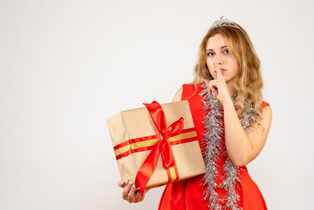 Vooraanzicht jonge vrouw in rode jurk kerstcadeau te houden